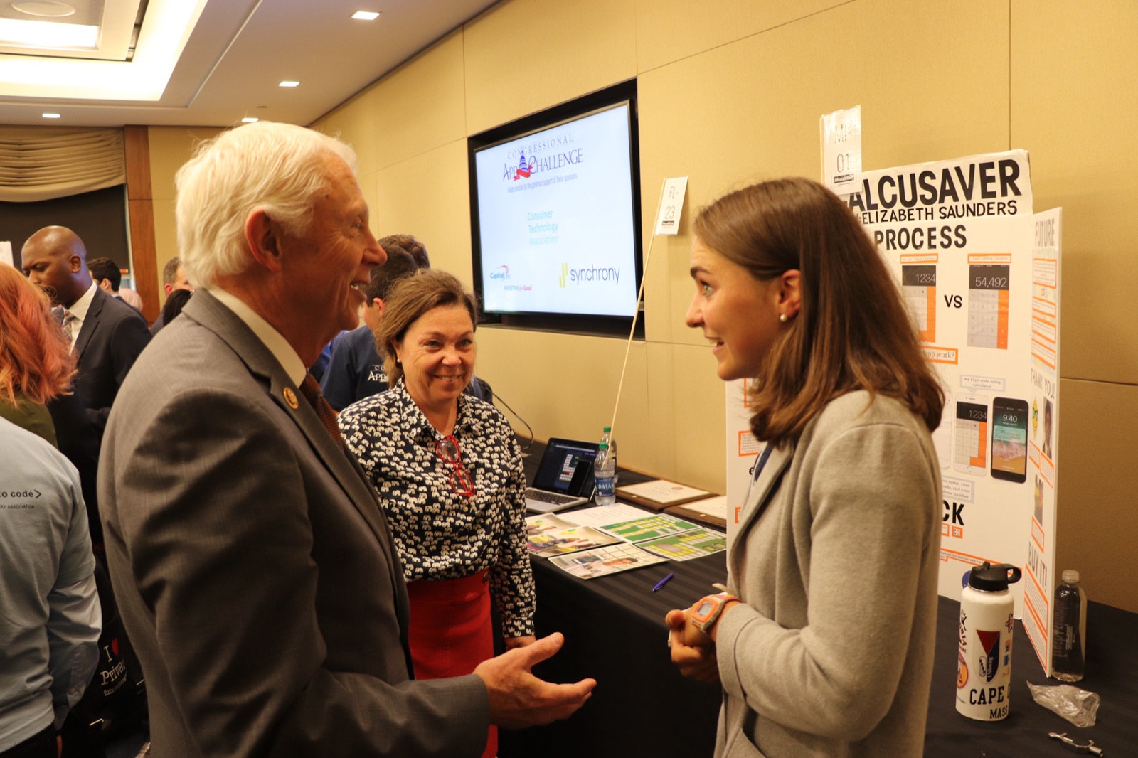 Elizabeth Saunders presenting CalcuSaver to a member of Congress at her exhibit booth