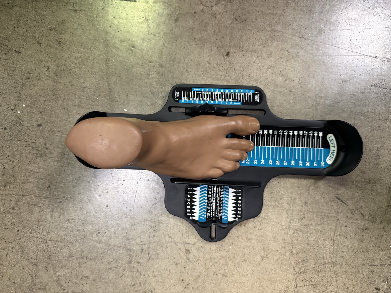 The prop foot positioned on a traditional Brannock-style boot-fitting device, the old-fashioned method the app aims to modernize
